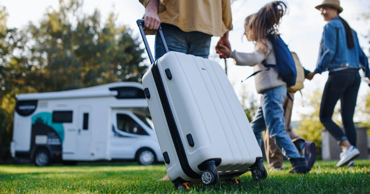 A family heading to their RV with a suitcase
