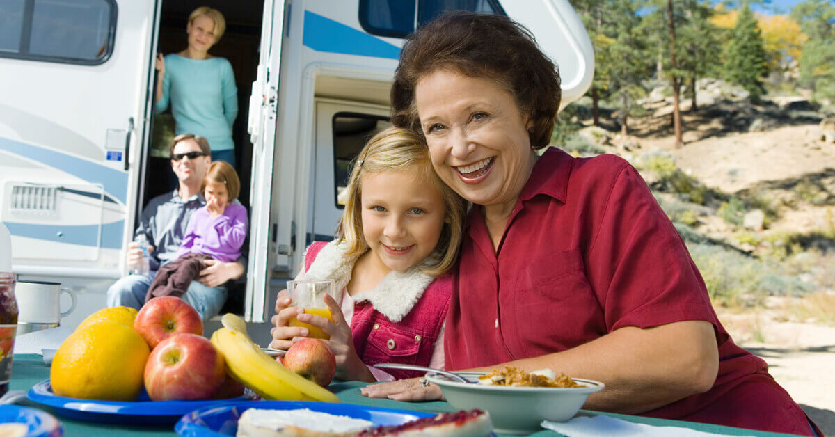 3 generations of a family outside of their RV enjoying the sunshine