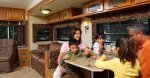 A family sitting at a table in their RV working on puzzles
