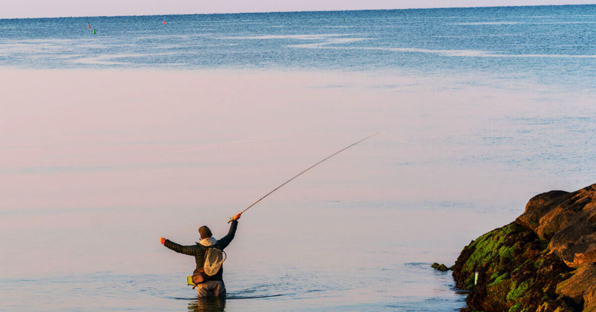 Man, fishing on the shore of Cape Cod Massachusetts