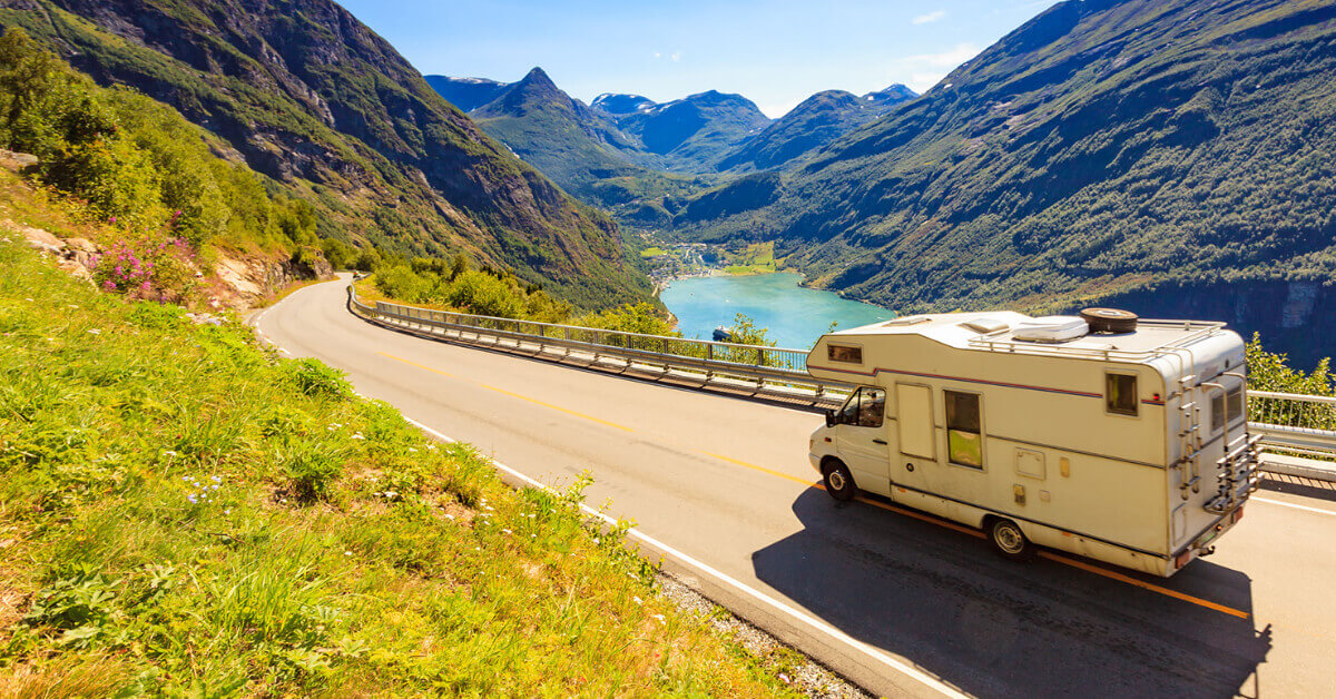 An RV traveling down a road next to a river