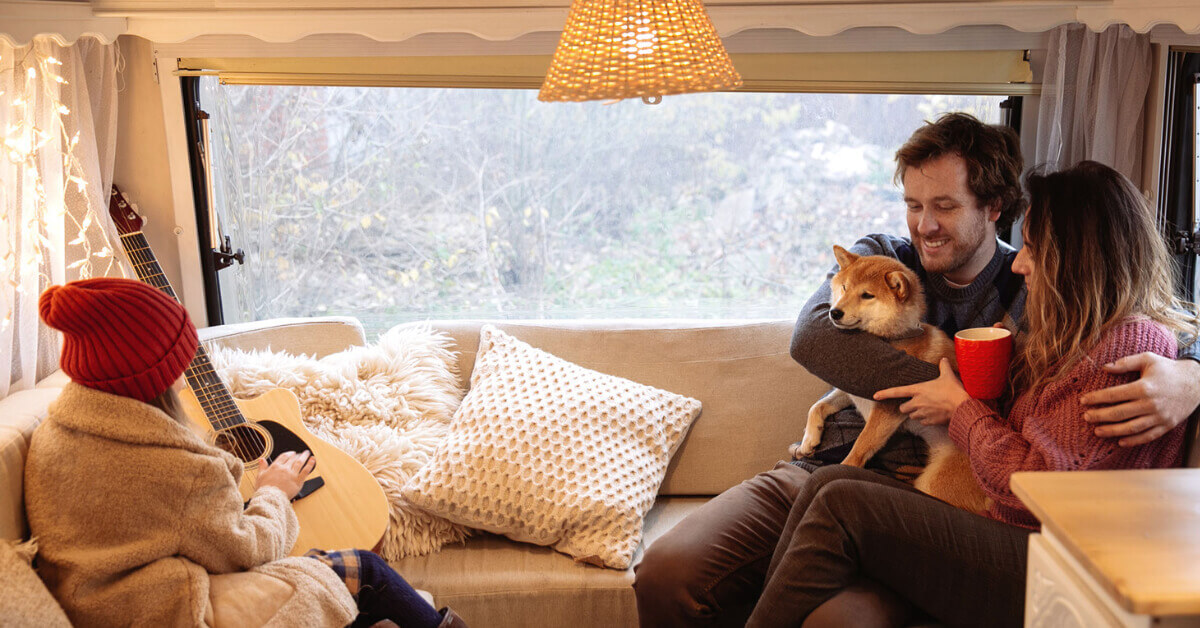 A family sitting inside their RV with their dog
