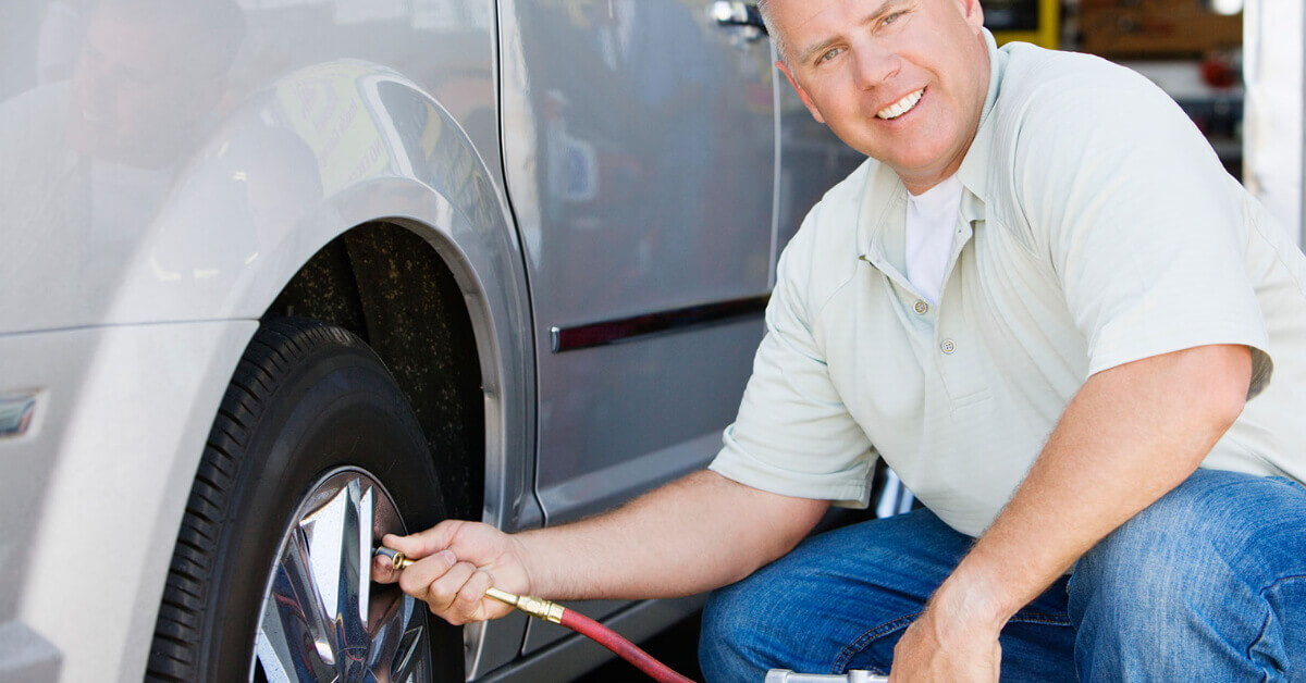 RVer checking the tire pressure on his RV's tires