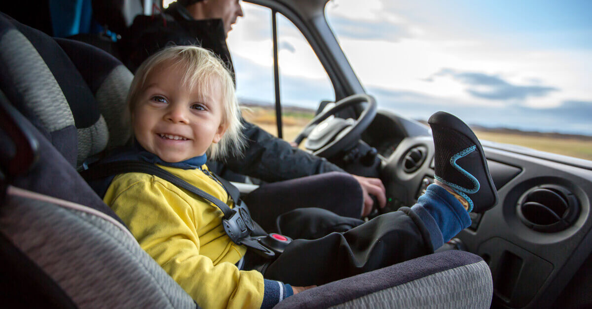 Little boy riding in an RV buckled into a car seat