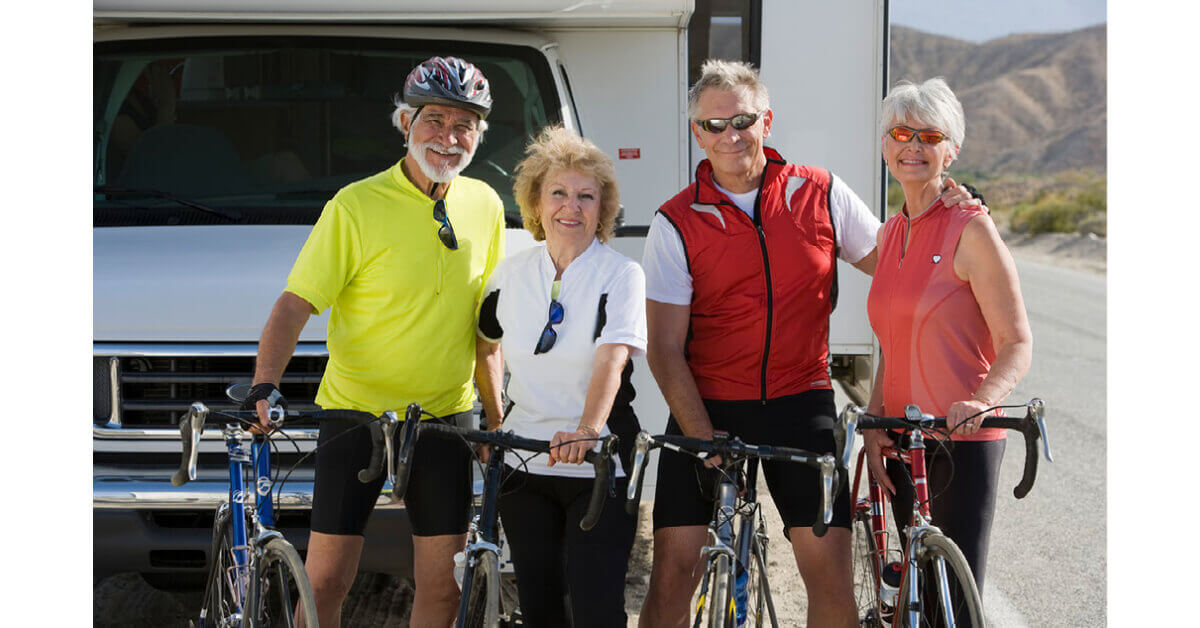 RVers holding their bicycles in front of an RV