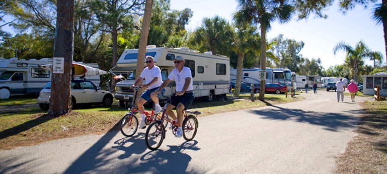 Two RVer Riding their bikes through the Shady Acres Travel Park located in Fort Myers Florida